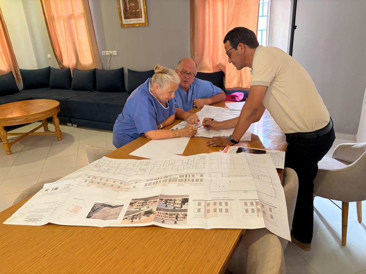 Examen des plans d'architecte du dispensaire avec Ahmed Boutkoum, Marie-Thérèse Pascuttini et Jean-Étienne Bazin