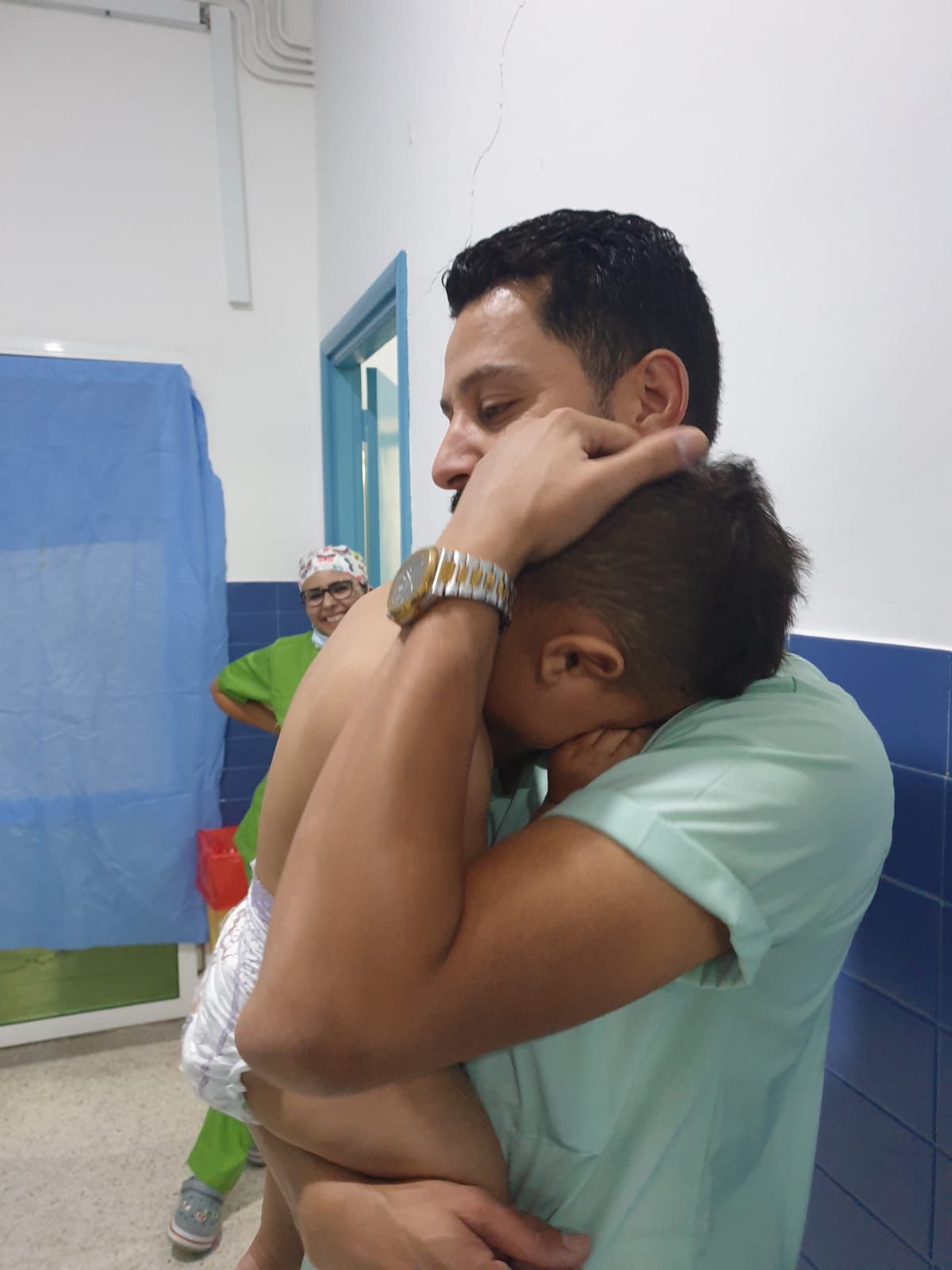 Père réconfortant son enfant auprès de l'équipe soignante